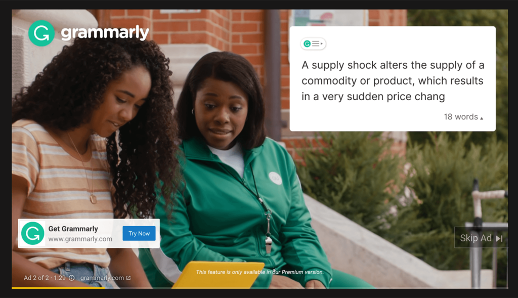 A Grammarly video ad featuring two students sitting outside, with an on-screen grammar suggestion overlay correcting a sentence. The ad promotes Grammarly’s premium features for improving writing.